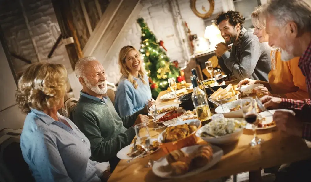Family gathered around festive Thanksgiving dinner table, smiling and celebrating